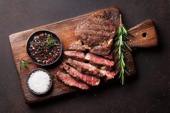 Grilled beef steak with spices on cutting board 1